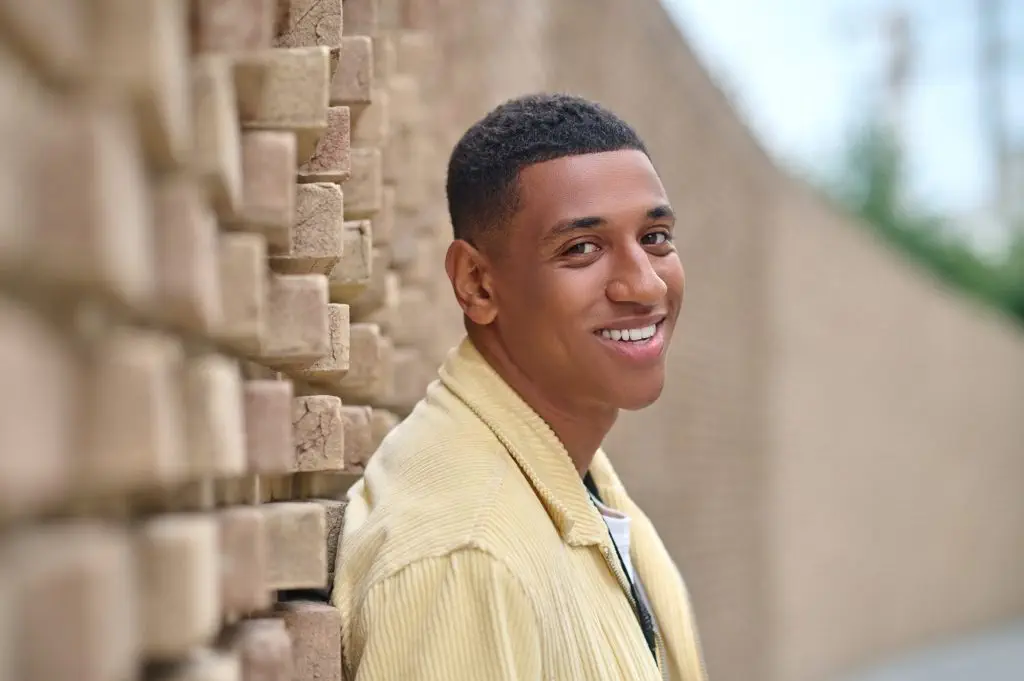 Headshot of young dark-skinned man in beige jacket