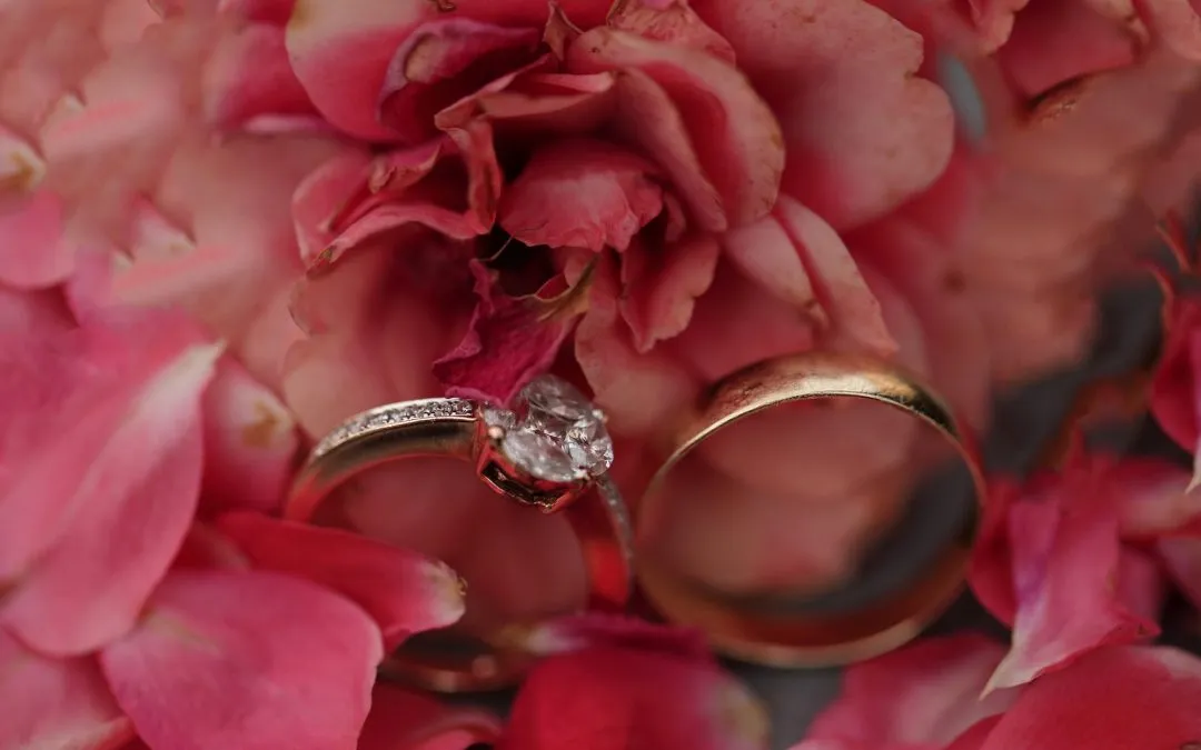 Wedding rings in-between pink blossoms