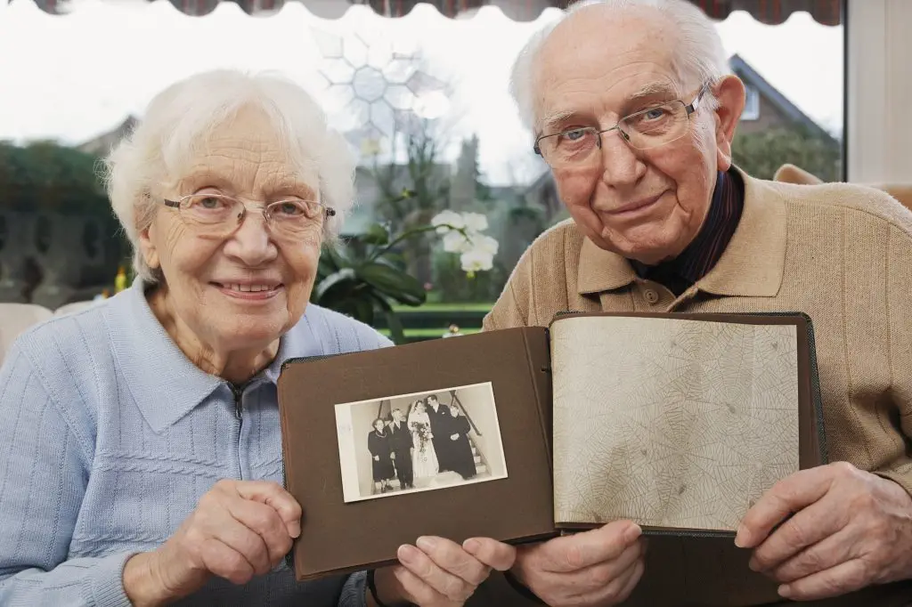 Senior couple showing old photograph of wedding day