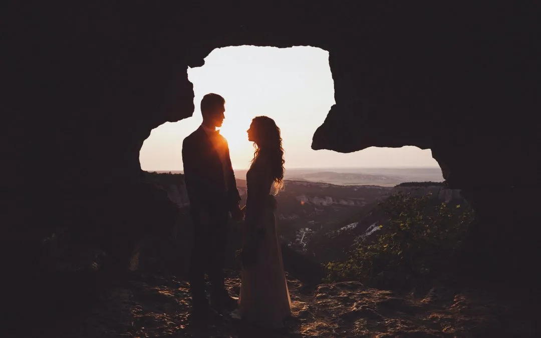 Unusual wedding photography. Sunset in muntains with silhouettes newlyweds