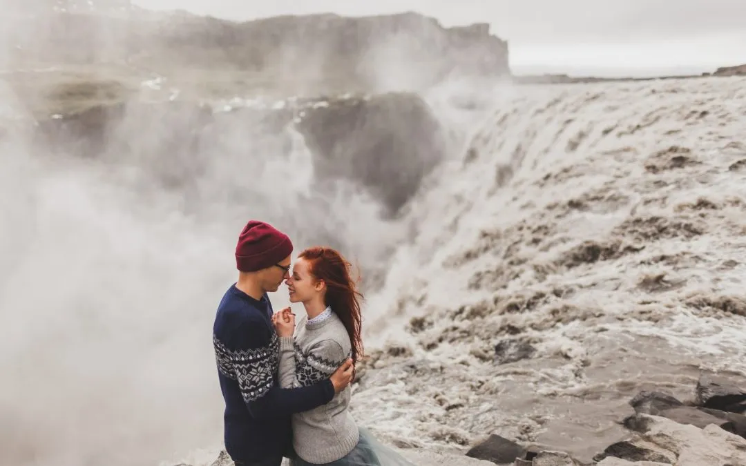 Young stylish couple in love kissing together near famous Icelandic landscape - Dettifoss waterfall