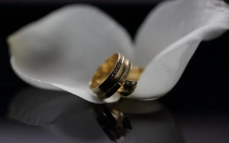 Golden wedding rings in white blossoms