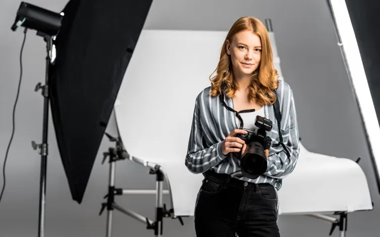 beautiful young female photographer working in professional photo studio